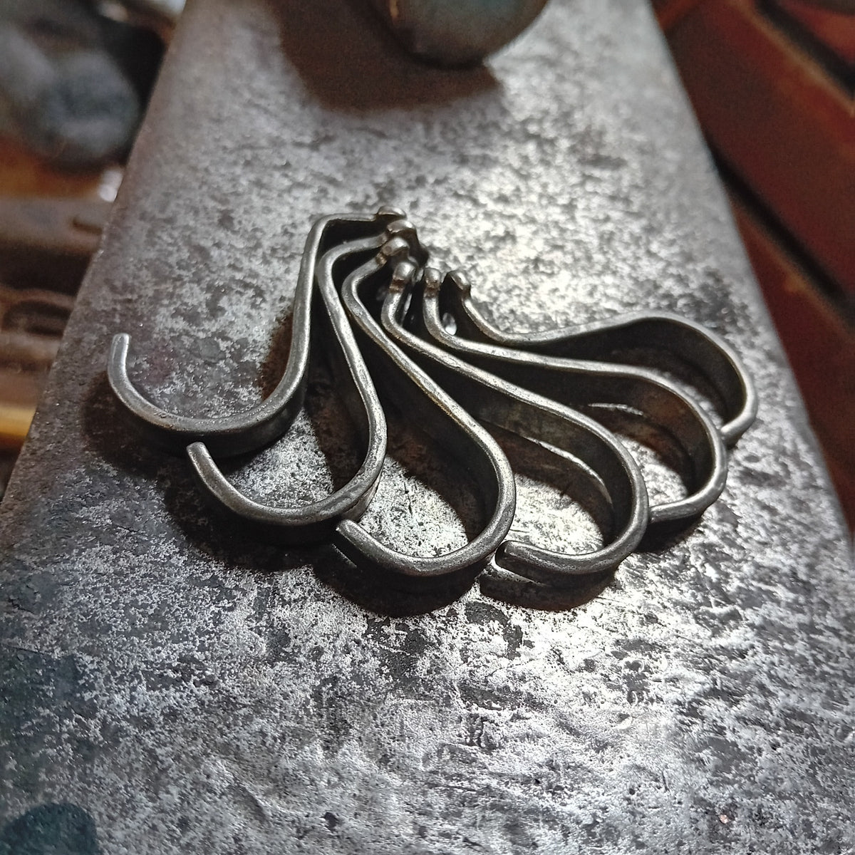 Group of hand-forged steel under-counter hooks with curved ends