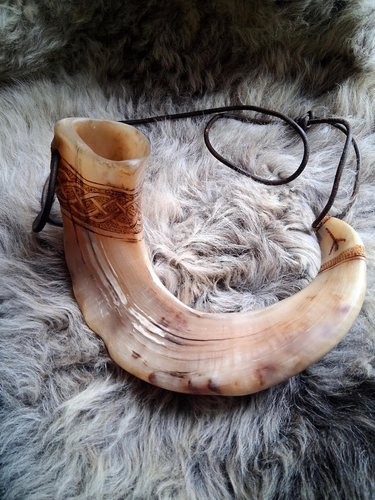 Hand-carved Orkney Boreray ram horn, full view with leather strap