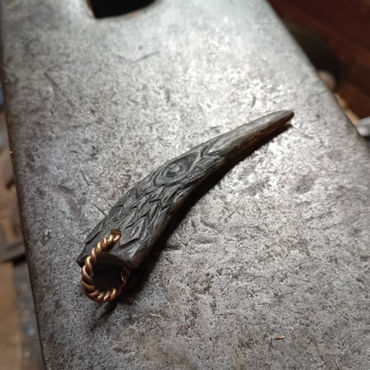 Close-up of hand-carved raven pendant showing natural horn grain and eye