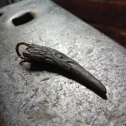 Raven head pendant showing carved feather detailing
