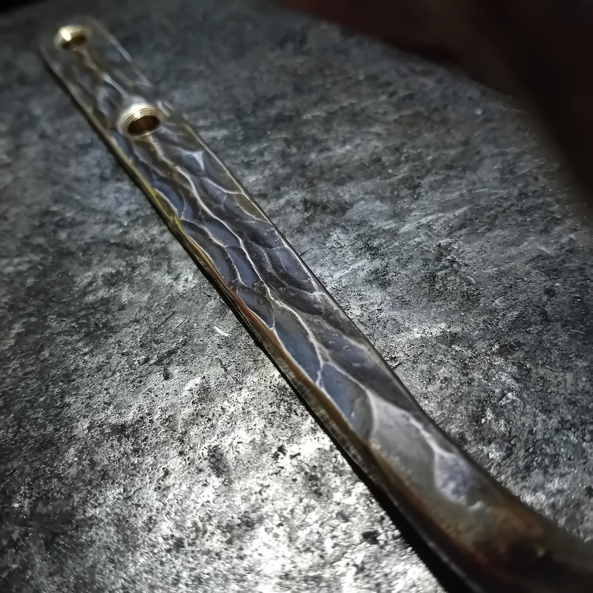 Close-up of textured solid brass wall hook stem and hammered surface