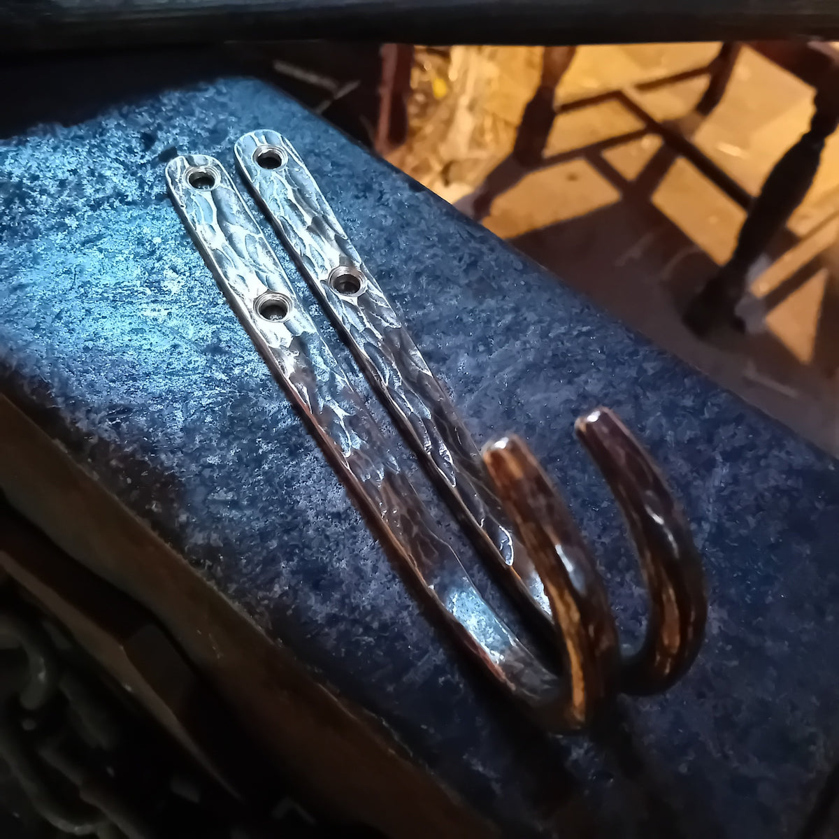 Pair of hand-forged brass wall hooks with polished hammer-marked surfaces
