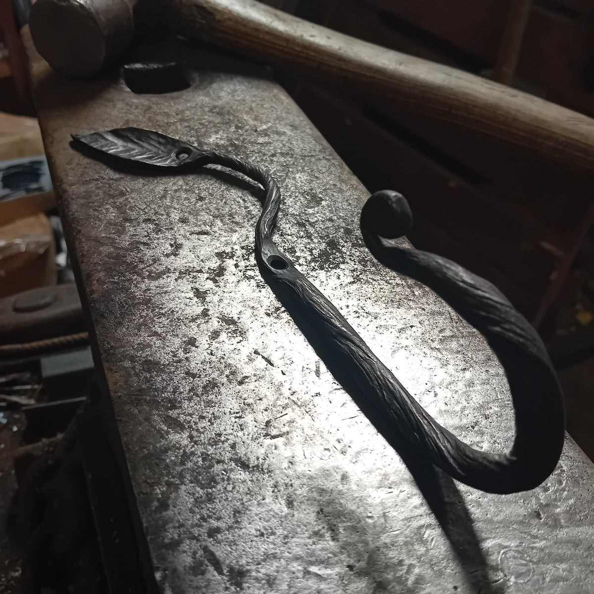 Full view of hand-forged steel leaf wall hook with two fixing holes