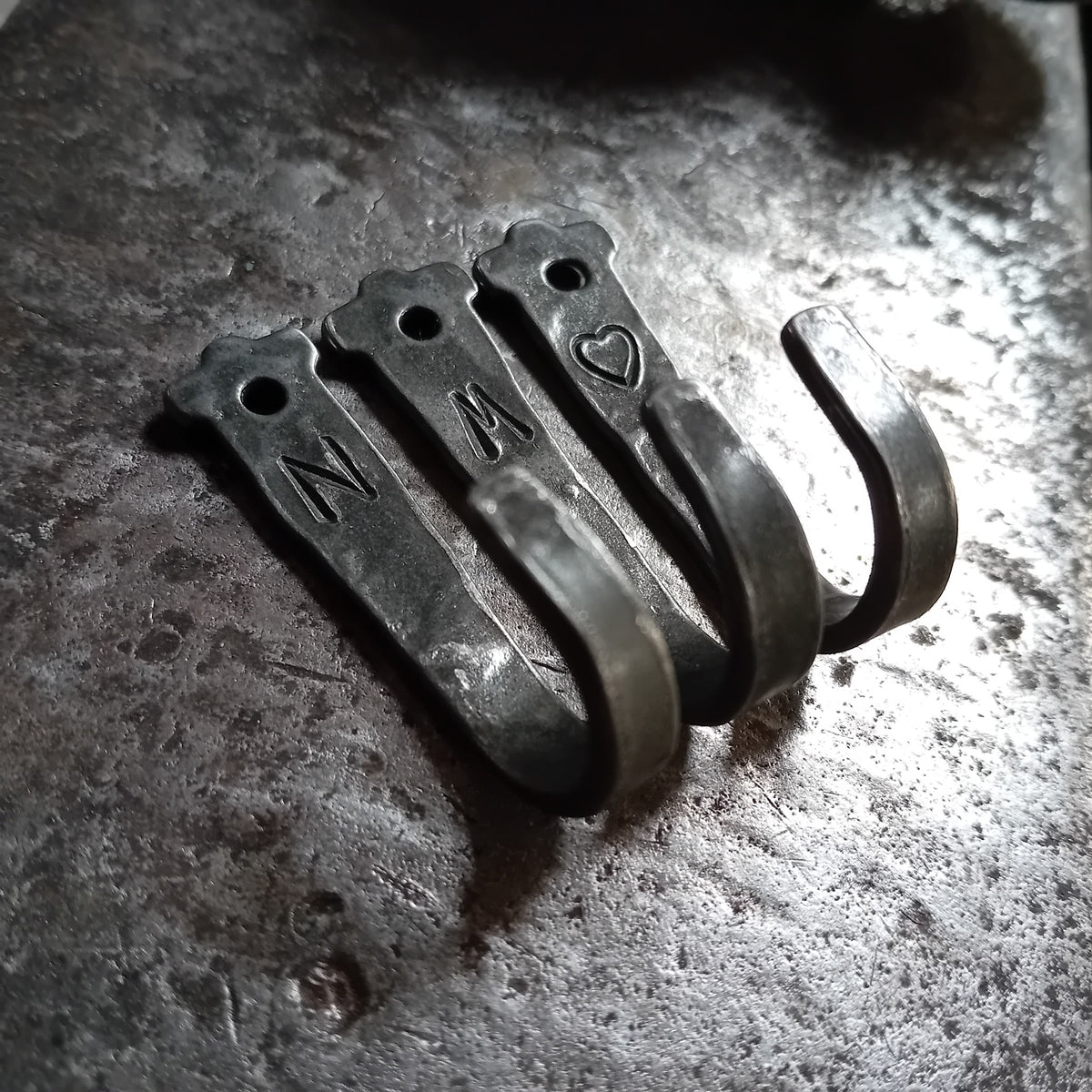 Close-up of letter and heart forged hooks