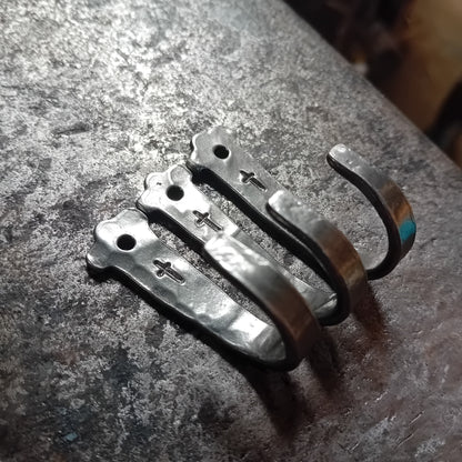 Three hand-forged steel wall hooks with engraved crosses